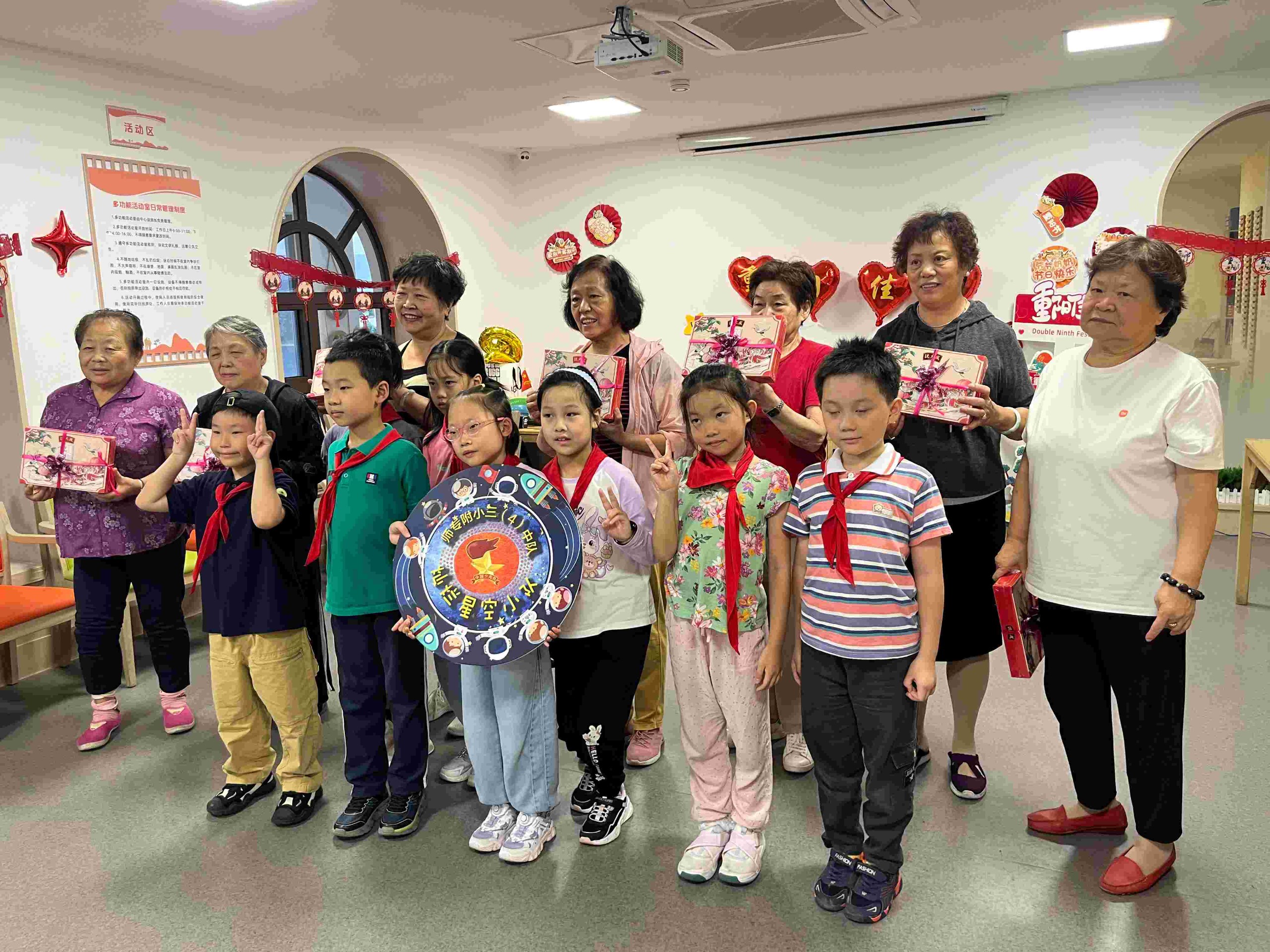五里桥街道第二日间照护中心重阳节师专附小学生慰问长者，与长者合影留念。